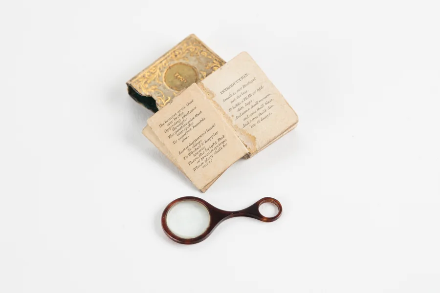 Un livre miniature ancien accompagné de sa loupe et de son étui.